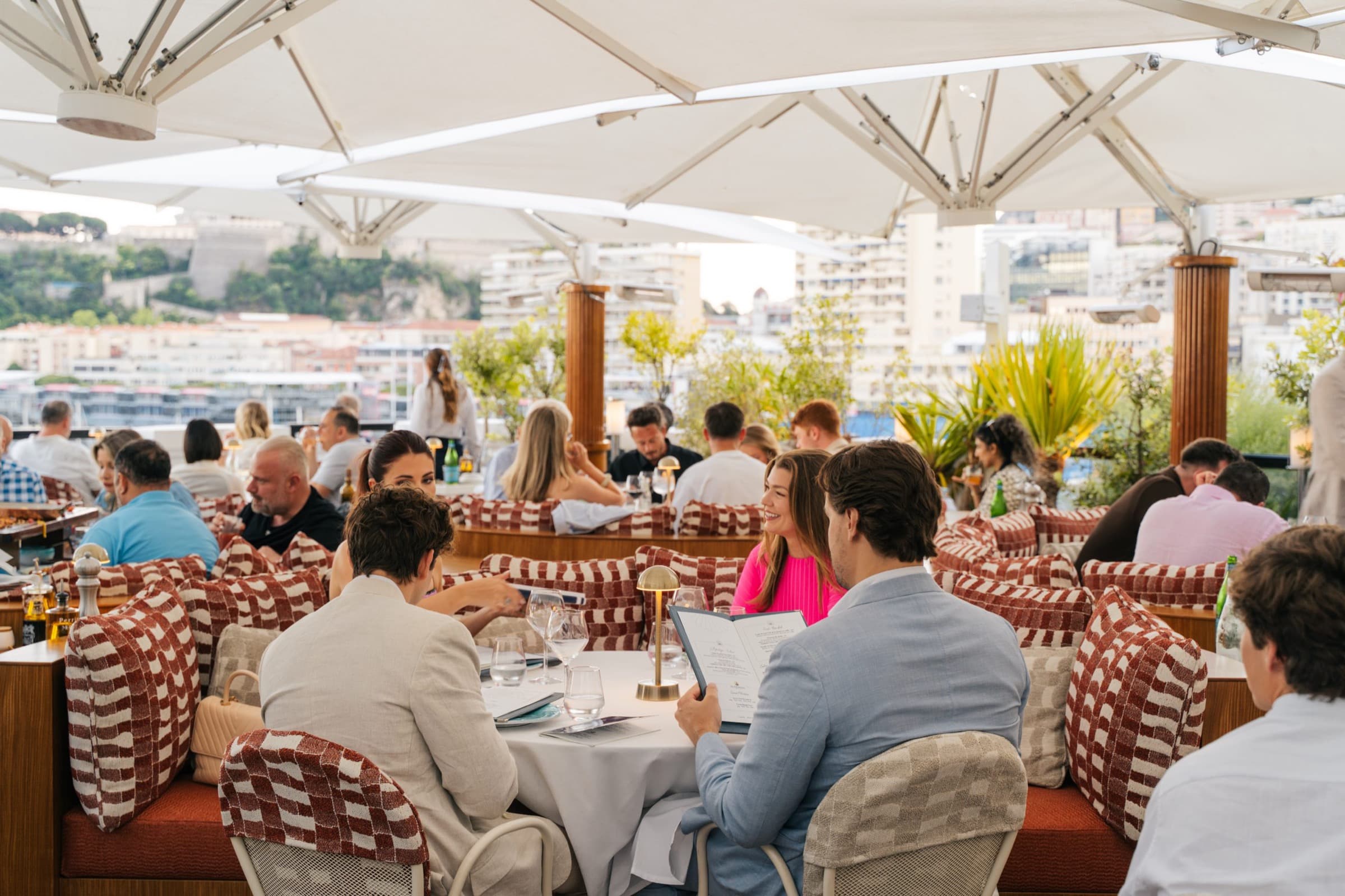 Le rooftop de La Môme Monaco sous les parasols, le port en contrebas