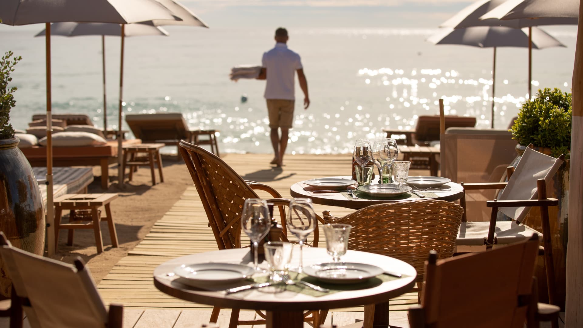 Le dîner sur le deck de La Réserve à la Plage à l'heure dorée